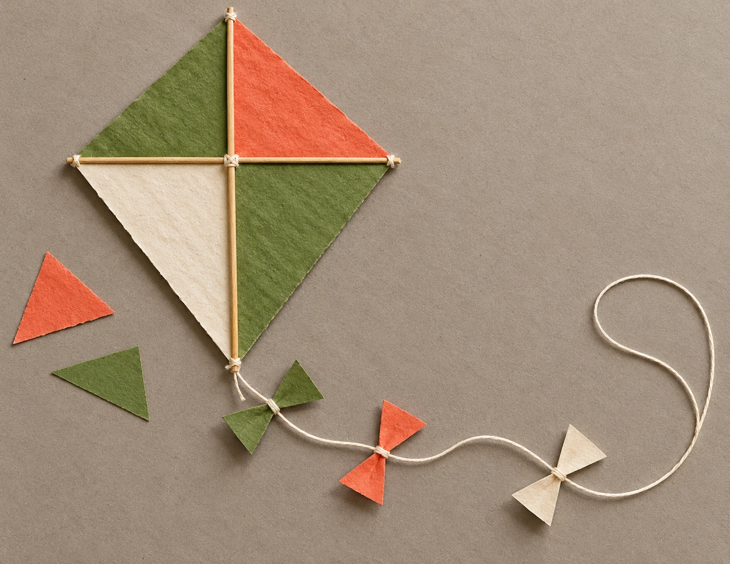 A tactile kite collage for observing diagonal edges and a central crossing Diamond paper kite made from green, coral and cream triangles with crossed wooden spars and three string bows
