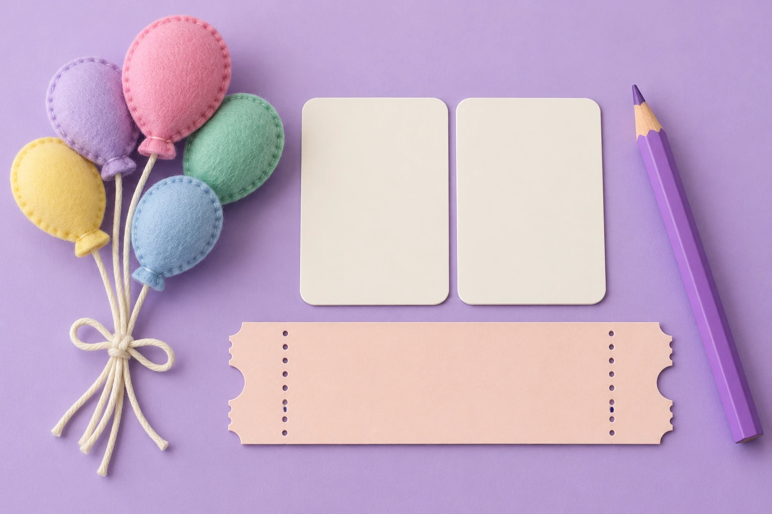 Pastel felt balloons beside two blank side-by-side tiles, an empty ticket strip and purple pencil